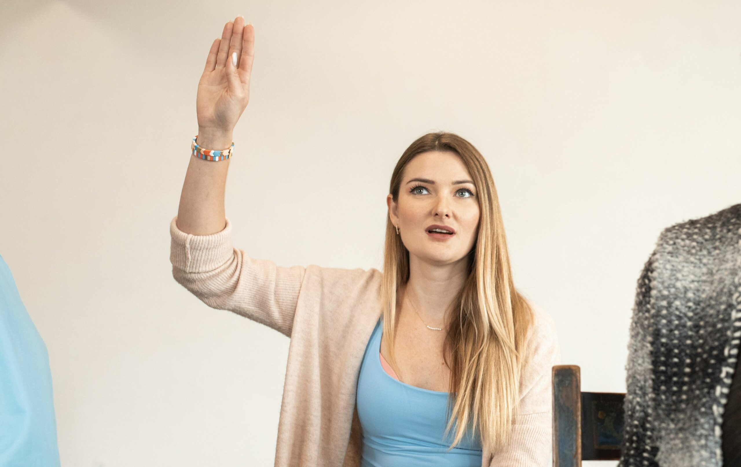 asking a question about the esthetics program a prospective student raising her hand to ask a question about the esthetics program