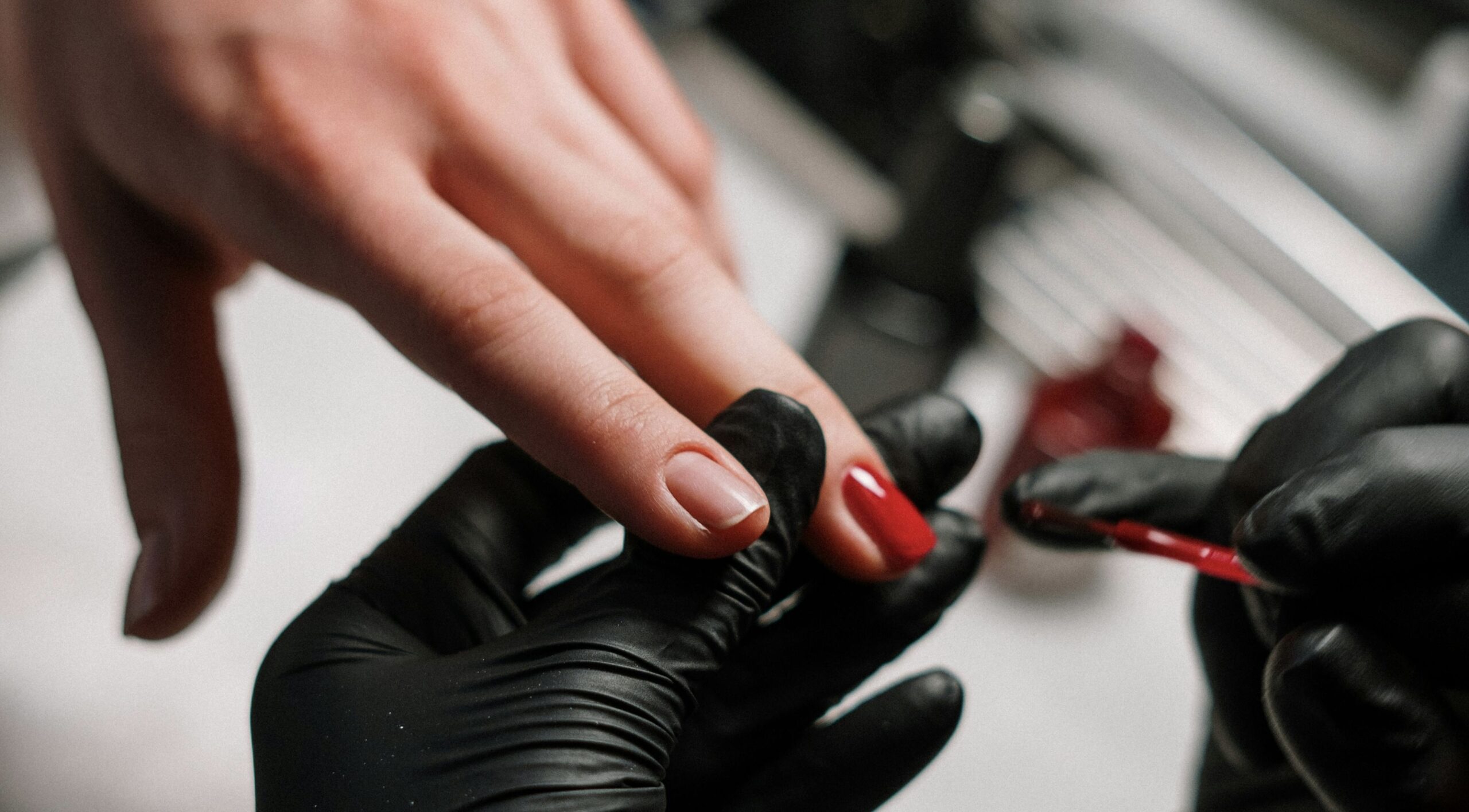 A model poses with a classic red regular polish manicure—elegant, timeless, and applied during a training session at the Winnipeg beauty school.