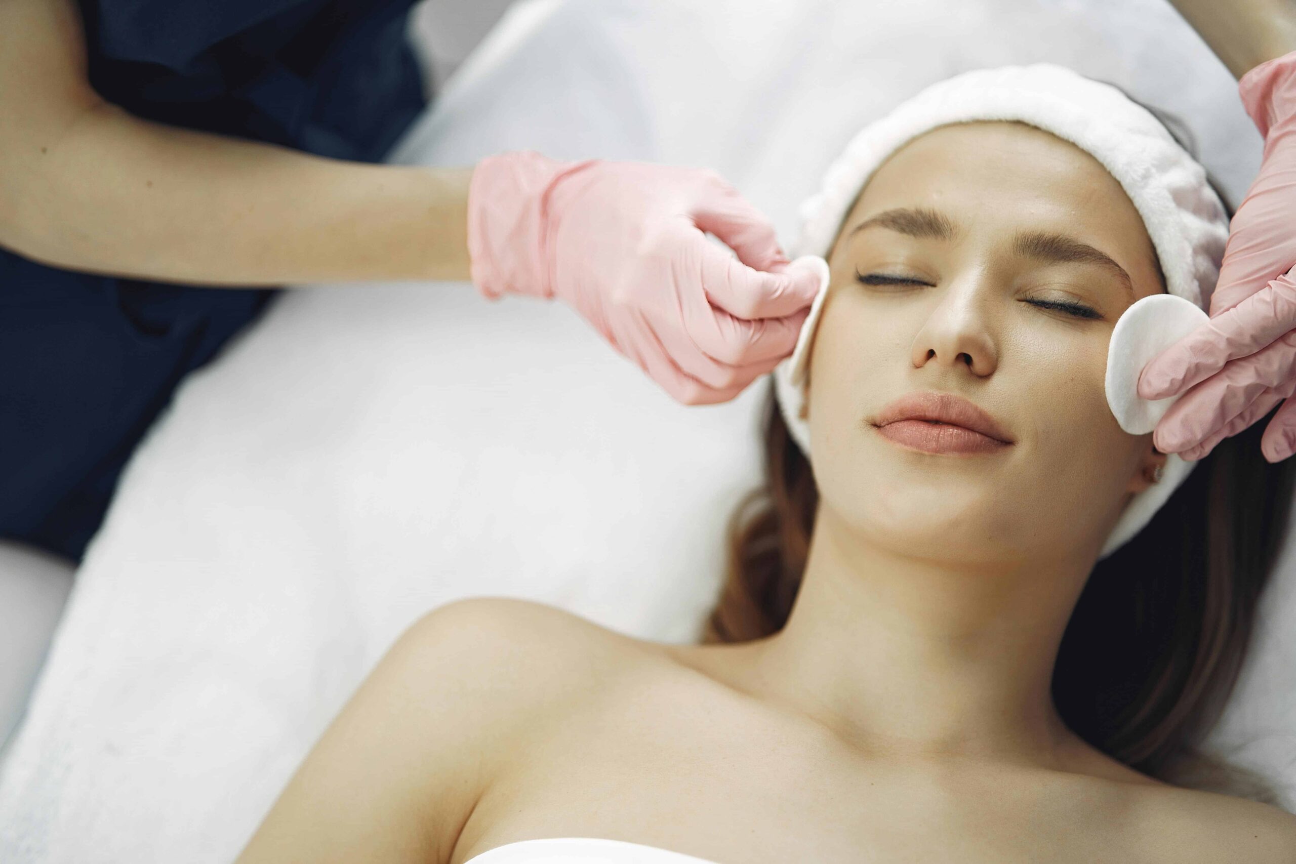  Licensed esthetician performing a facial on a client, showing one of the best images for beauty marketing with clean lighting and a professional spa setting