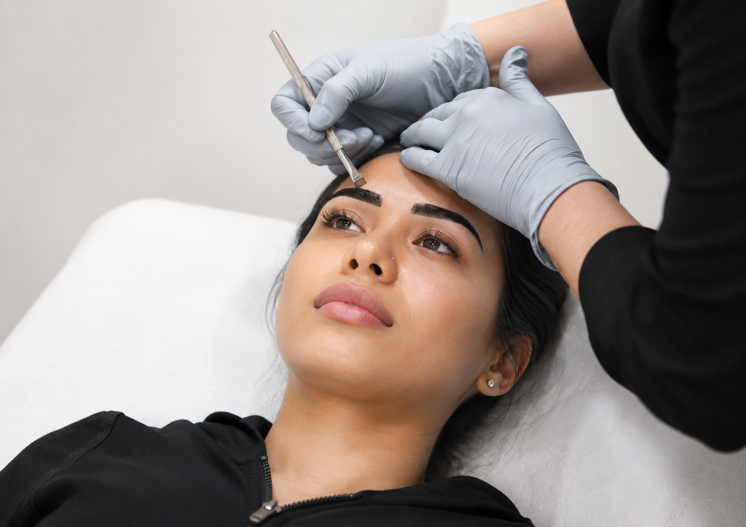 Student apply brow henna dye on model