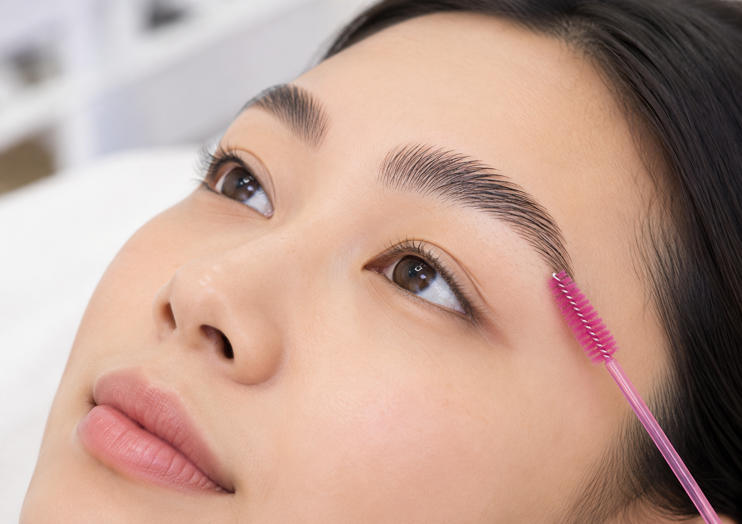 Brow spool combing through a person's eyebrow