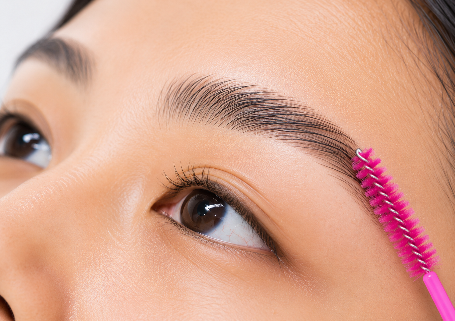 Brow spool combing through a person's eyebrow